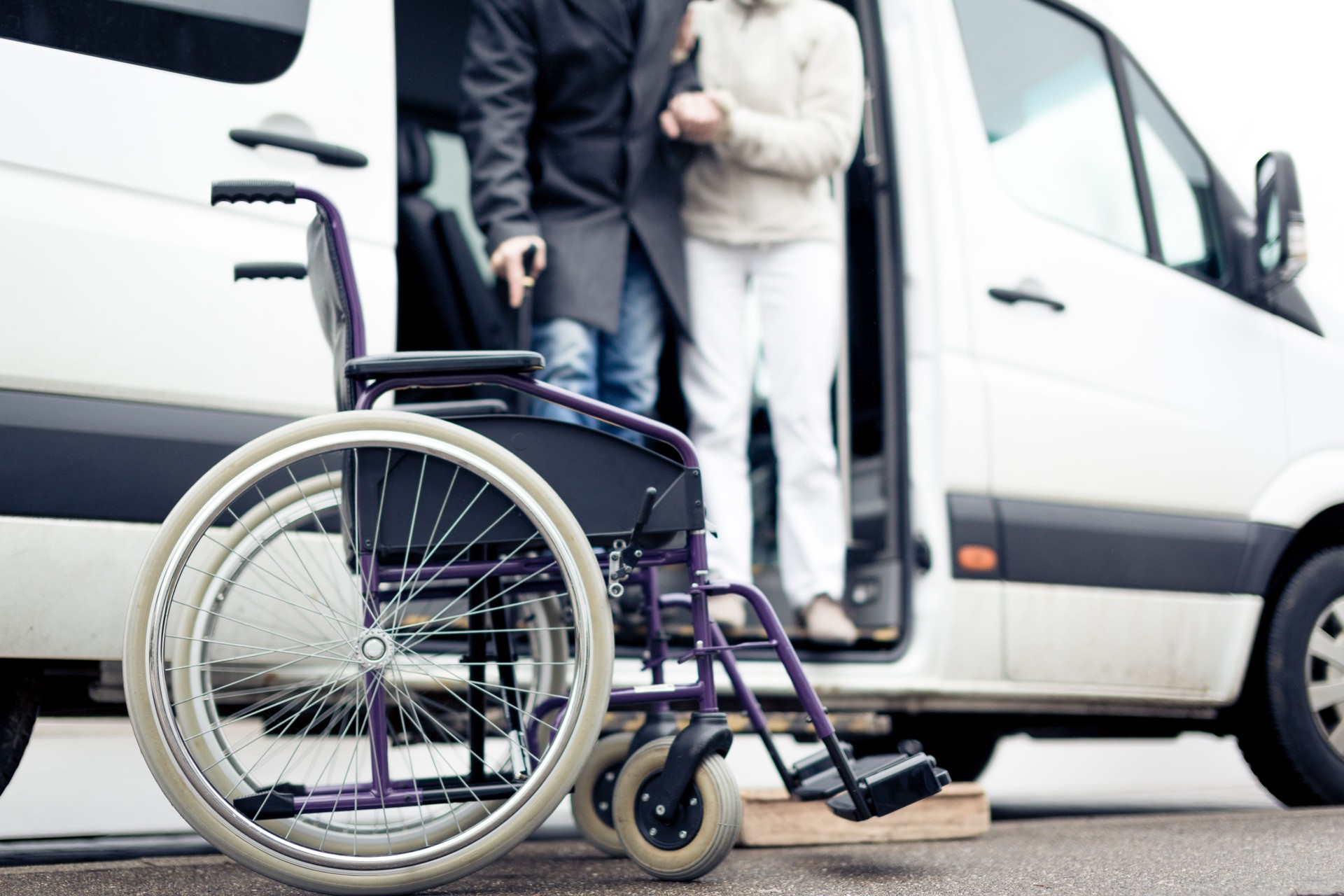 Driver helping person in wheelchair to an appointment or grocery shopping.